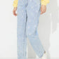 Bella Road Daisy Straight Jeans with Pockets, buttoned and floral-patterned, styled with a yellow top and white sneakers.