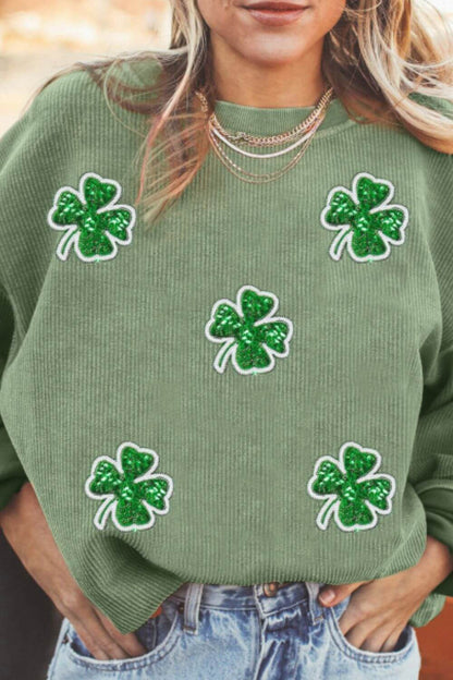 Woman wearing a green sweatshirt with sequin clover designs, perfect for casual outings and St. Patrick's Day festivities.