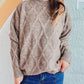 Woman wearing Bella Road Diamond Round Neck Long Sleeve Sweater with unique diamond pattern and classic round neck design.