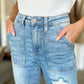 Woman wearing Judy Blue distressed straight jeans with patch pockets and a white top.