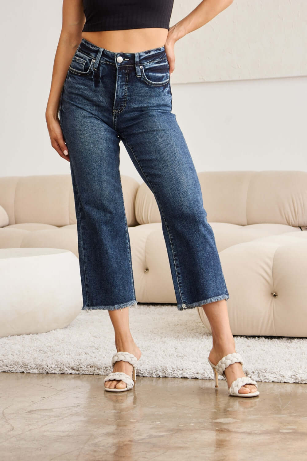 Woman wearing Tummy Control High Waist Raw Hem Jeans by RFM, showing stylish and flattering tummy control fit with a trendy raw hem detailing.