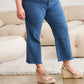 Woman wearing Crop Chloe Full Size Tummy Control High Waist Raw Hem Jeans (RFM Jeans) standing indoors.