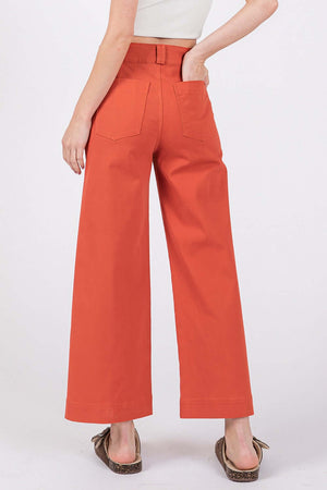 Wide leg cropped pants in red with back pockets and an adjustable button closure for a modern and comfortable fit.