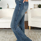 High Waist Tummy Control Flare Judy Blue Jeans in medium wash being modeled indoors, showcasing flattering fit and retro style.