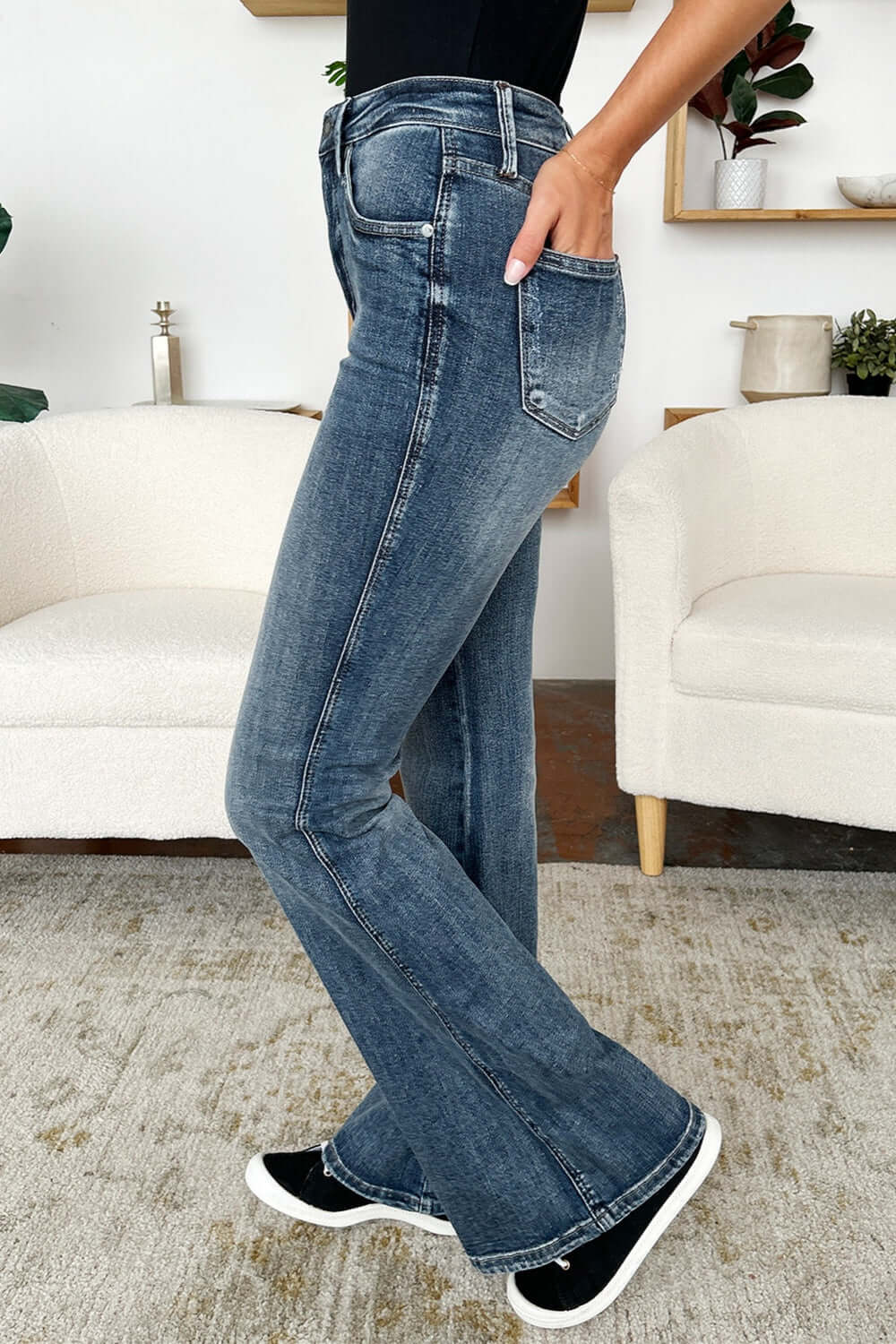 High Waist Tummy Control Flare Judy Blue Jeans in medium wash being modeled indoors, showcasing flattering fit and retro style.