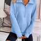 Woman wearing light blue Ivy Lane Half Zip Raglan Sleeve Sweatshirt with front pocket detail, styled with black shorts.