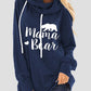 Woman wearing a navy blue hoodie with "Mama Bear" graphic and drawstrings.