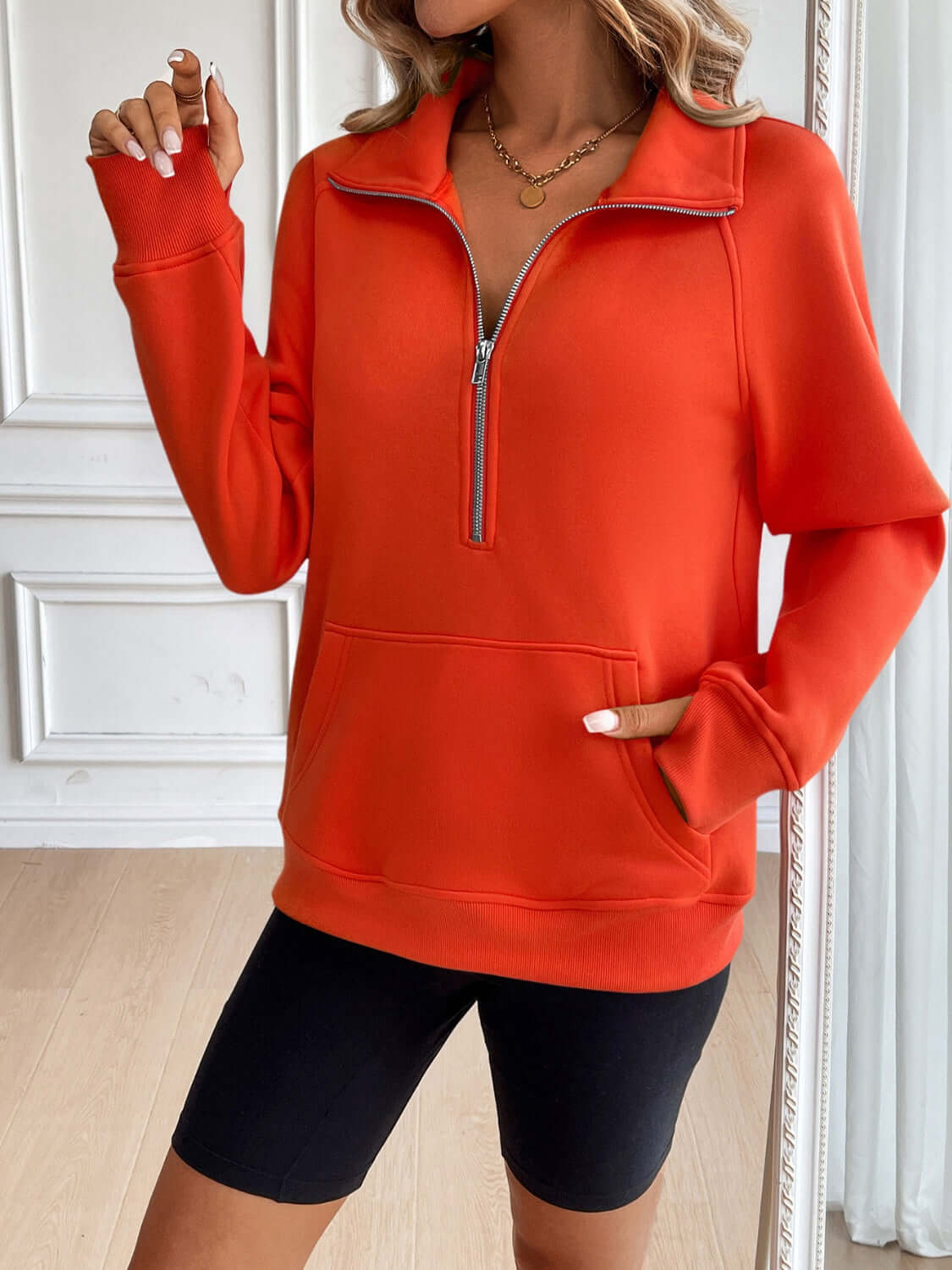 Ivy Lane Half Zip Raglan Sleeve Sweatshirt in vibrant red, featuring a front pocket and long sleeves, styled with black shorts.