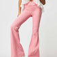 Woman wearing pink asymmetric waist flare jeans and a white ruffled top, showcasing a stylish and trendy outfit ideal for standing out.