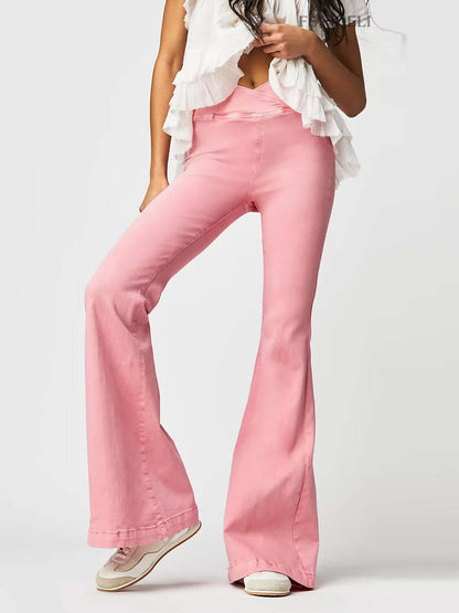 Woman wearing pink asymmetric waist flare jeans and a white ruffled top, showcasing a stylish and trendy outfit ideal for standing out.