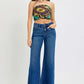 Model wearing RISEN Tummy Control High Rise Wide Leg Jeans with trendy top, showcasing stylish fit and pockets.