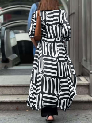 Woman wearing Bella Road Contrast Collared Neck Long Sleeve Longline Shirt with black and white geometric pattern, carrying a brown bag