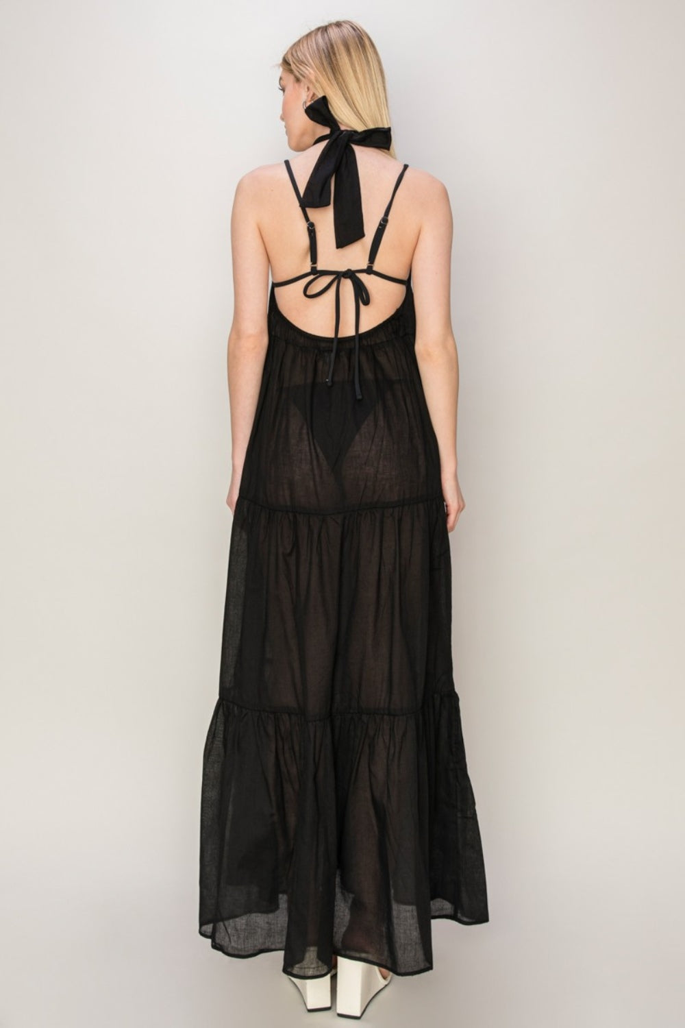 Back view of a black HYFVE halter neck maxi dress with tie-back and tiered silhouette, perfect for warm days.