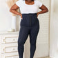 Woman wearing Heimish full size waist trainer corset leggings, showcasing high-performance support and sleek hourglass silhouette in a white top.