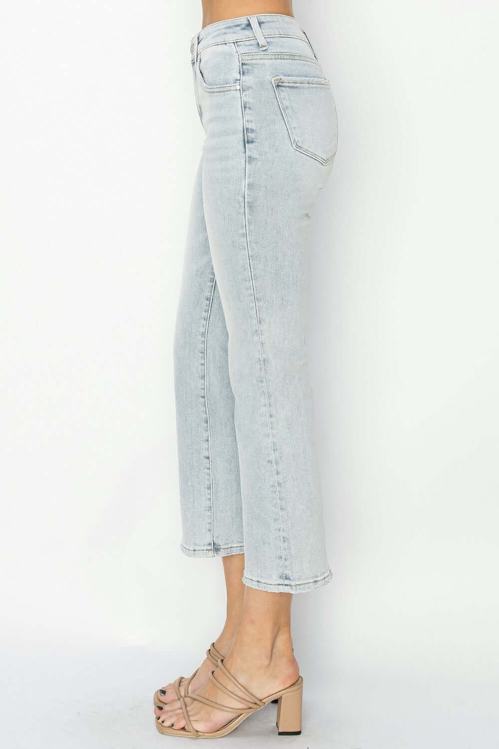 Side view of RISEN Full Size Mid Rise Cropped Flare Jeans in light wash, showcasing cropped flare leg and flattering mid-rise waist.