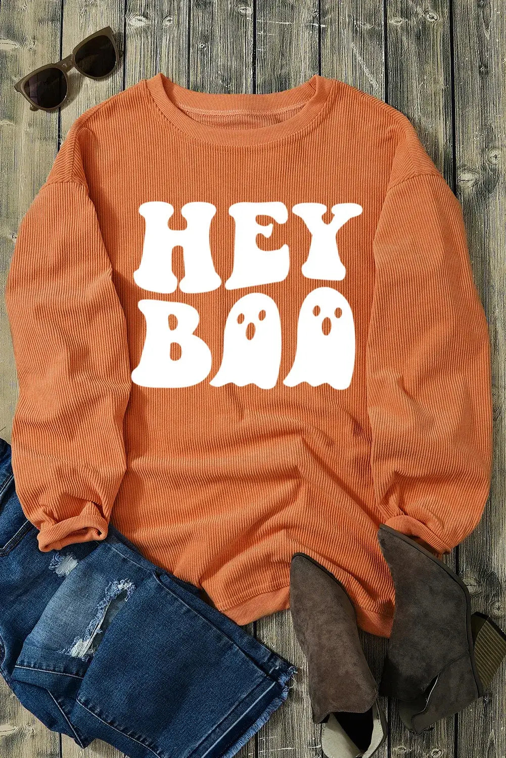 Bella Road Hey Boo Graphic Round Neck Long Sleeve Sweatshirt in orange with Halloween ghost design, paired with jeans and boots.