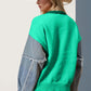 Woman wearing a vibrant green raw edge long sleeve sweater with a star pattern and cowboy hat, showcasing a unique and playful style.