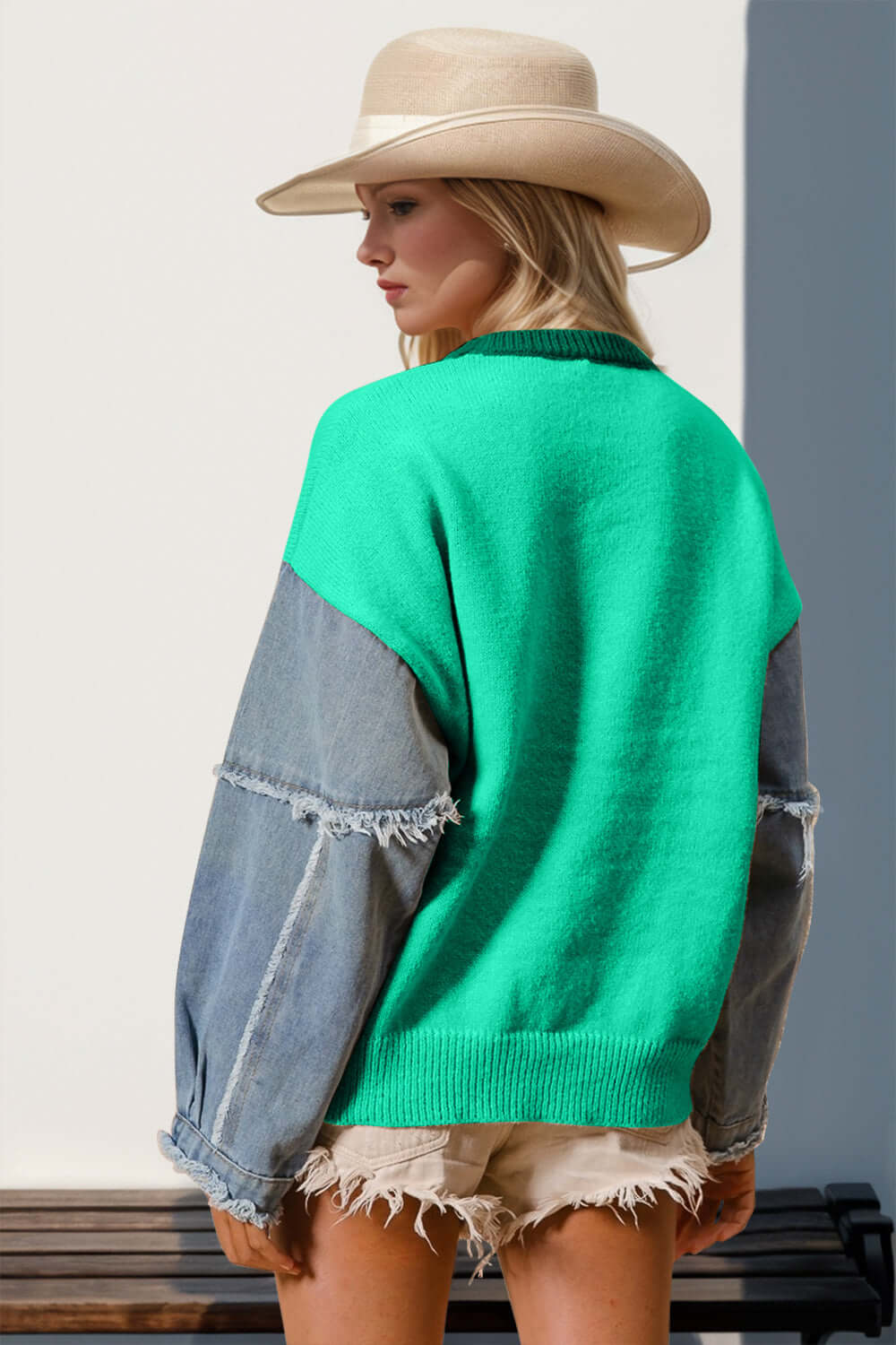 Woman wearing a vibrant green raw edge long sleeve sweater with a star pattern and cowboy hat, showcasing a unique and playful style.