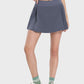 Stylish woman in a pleated mid-rise waist active skirt, perfect for workouts and casual outings.