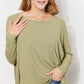 Woman wearing oversized super soft rib layering top with sharkbite hem and round neck in olive green