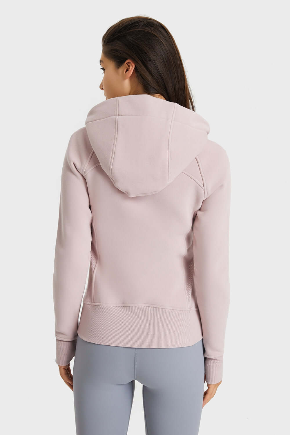 Back view of female in Millennia Zip Up Hooded Sports Jacket, showcasing stylish seam detailing and cozy hood.