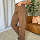 Woman wearing RFM Full Size High Rise Garment Dye Wide Leg Jeans in rich brown color, styled with a white top and sneakers.