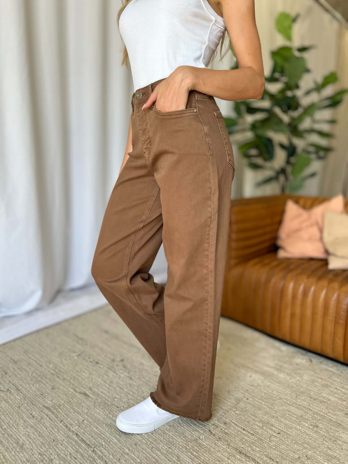 Woman wearing RFM Full Size High Rise Garment Dye Wide Leg Jeans in rich brown color, styled with a white top and sneakers.