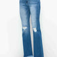 Distressed high rise bootcut jeans with raw hem, styled for a trendy and casual look. Perfect for pairing with boots or heels.