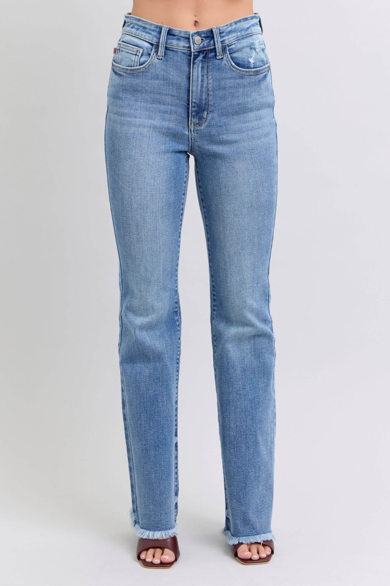 Judy Blue high rise bootcut jeans with raw hem, showcasing a fashionable and flattering blue denim style.