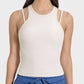 Model showcasing the Millennia Cutout Round Neck Racerback Active Tank in a stylish off-white color, perfect for workouts.