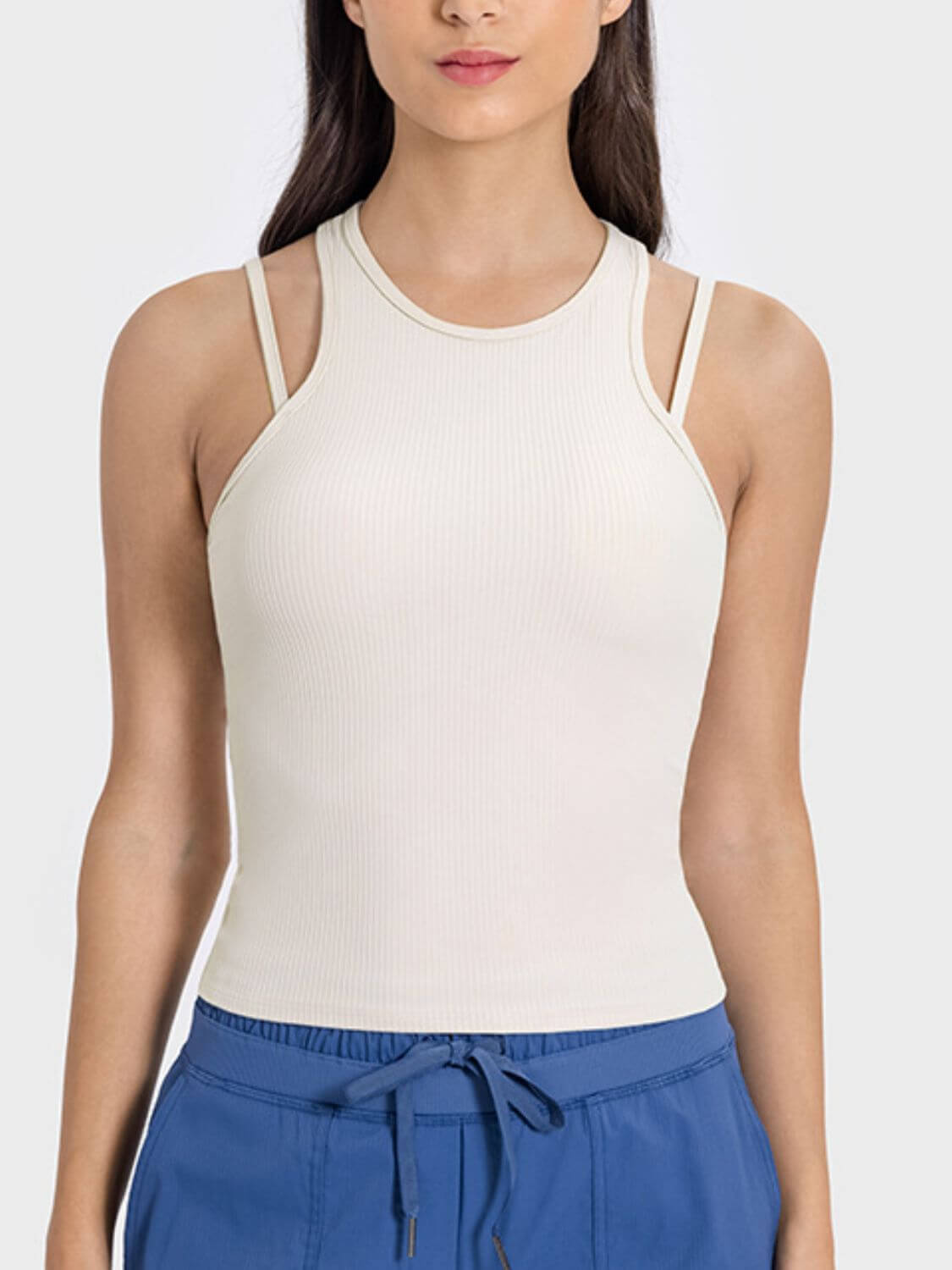 Model showcasing the Millennia Cutout Round Neck Racerback Active Tank in a stylish off-white color, perfect for workouts.