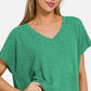 Woman wearing a green V-neck short sleeve T-shirt paired with jeans, showcasing casual and comfortable fashion style.