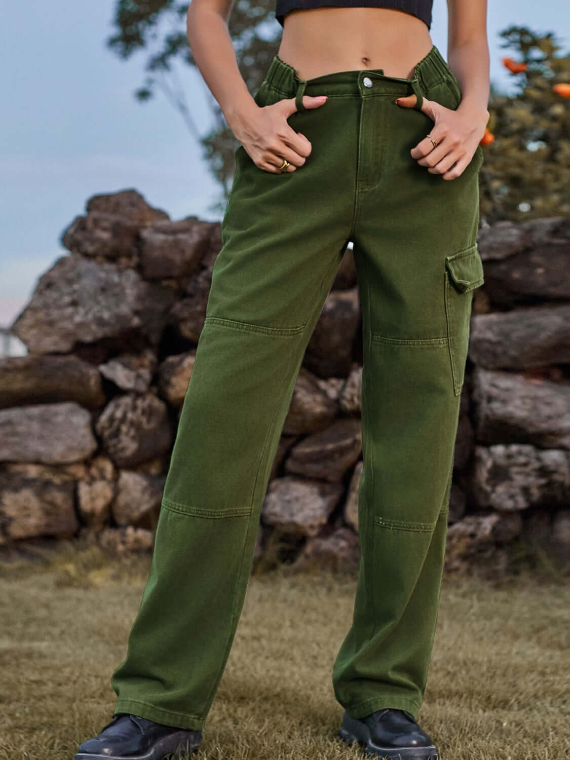 Model wearing Bella Road High Waist Cargo Straight Jeans in green standing outdoors.