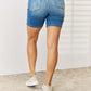 Back view of woman wearing Tummy Control Double Button Bermuda Denim Shorts by Judy Blue Jeans