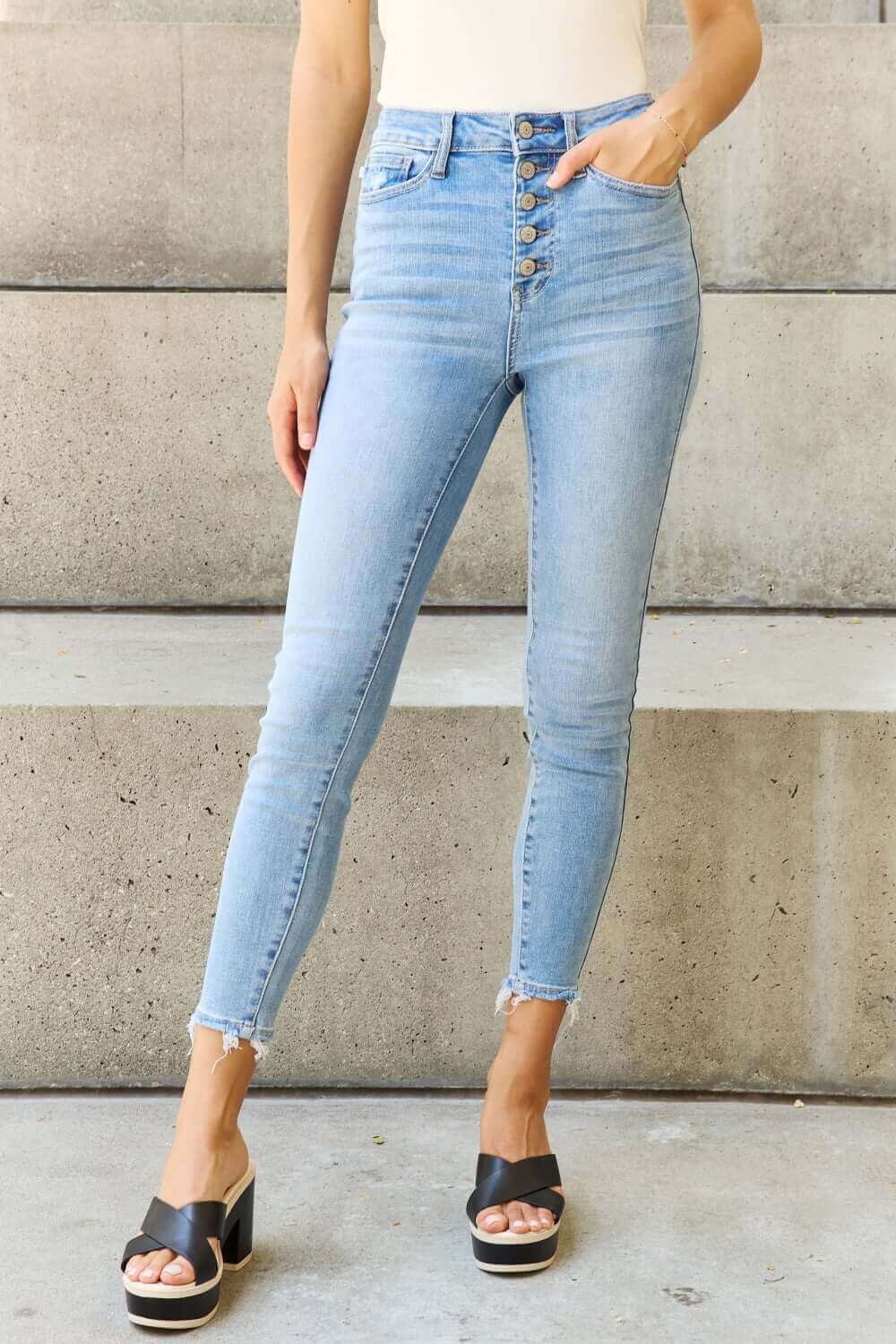 Woman wearing Judy Blue Jeans Button Fly Raw Hem Jeans with pockets, casual light blue denim, perfect for everyday comfort and style