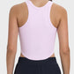 Back view of a pink Millennia round neck racerback active tank with moderate stretch, perfect for workouts.