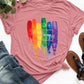 Pink graphic round neck short sleeve T-shirt with rainbow "Love Wins" design, paired with denim jeans and sandals placed beside.