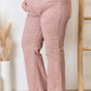 Model wearing Risen high-rise ankle flare jeans in pink, showcasing flattering silhouette with pocket details.