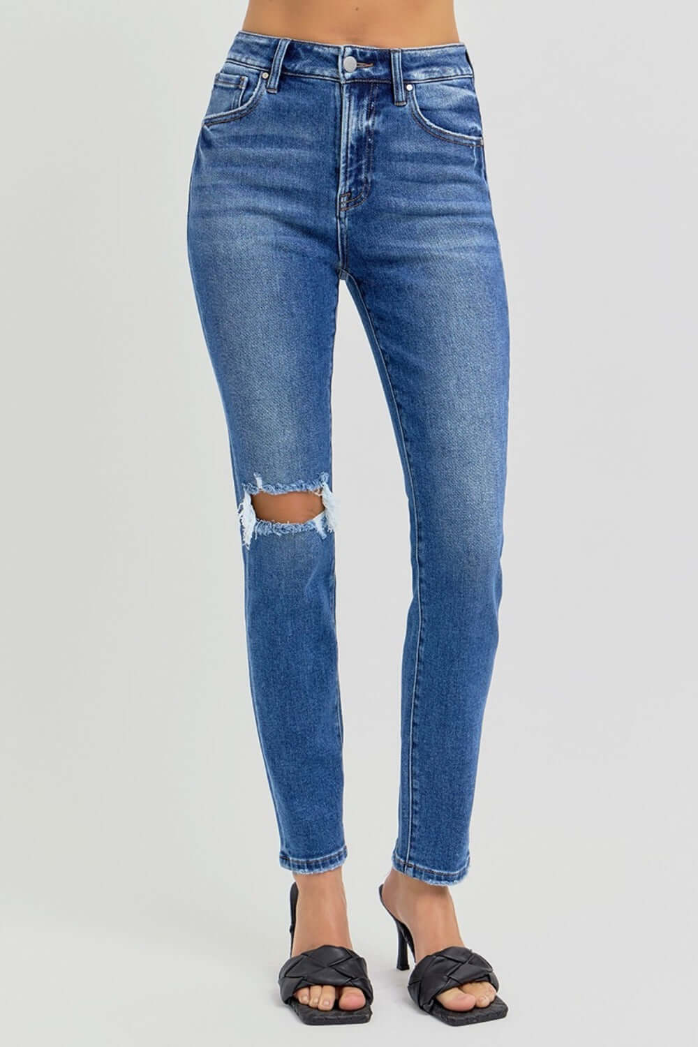 High rise ankle skinny jeans with knee distressing, featuring a flattering fit and slightly stretchy material, perfect for casual or dressy wear