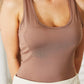 Woman wearing a brown Everyday Full Size Basic Tank Bodysuit with a scoop neckline and white skirt.