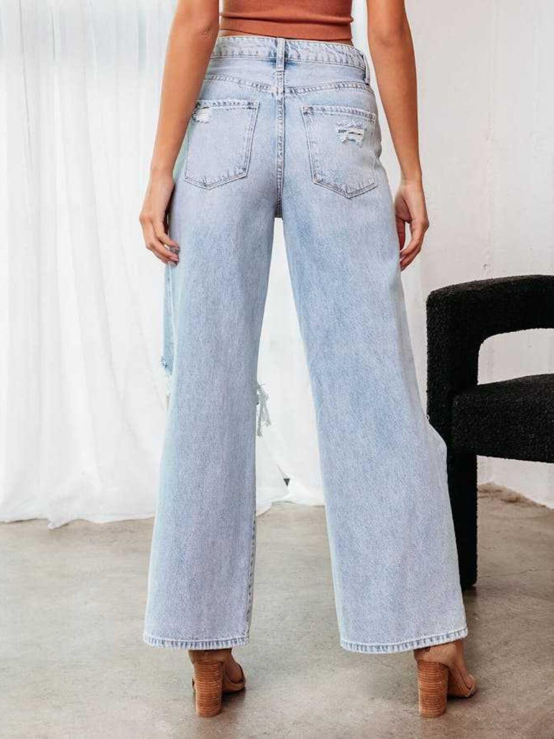 Woman wearing Bella Road distressed wide leg jeans with pockets, back view, showing no-stretch light blue denim fabric.