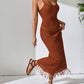 Woman wearing a rust-colored openwork scoop neck cover-up dress with tassels, highlighting its semi-sheer design and slight stretch material.