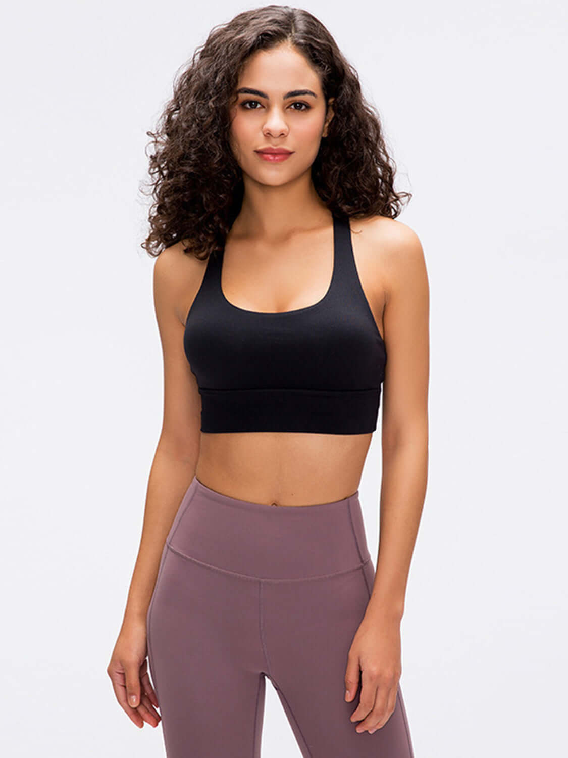 Model wearing black Millennia Crisscross Scoop Neck Active Tank, showcasing stylish design for workouts.