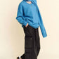 Stylish model in blue V-neck dropped shoulder sweater with scarf, paired with black wide-leg pants and sneakers.