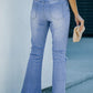 Back view of a woman wearing Bella Road Button-Fly Distressed Raw Hem Flare Jeans in light blue, holding a beige purse.