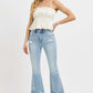 Model showcasing RISEN full size raw hem distressed cropped flare jeans with a stylish white top and trendy sandals.