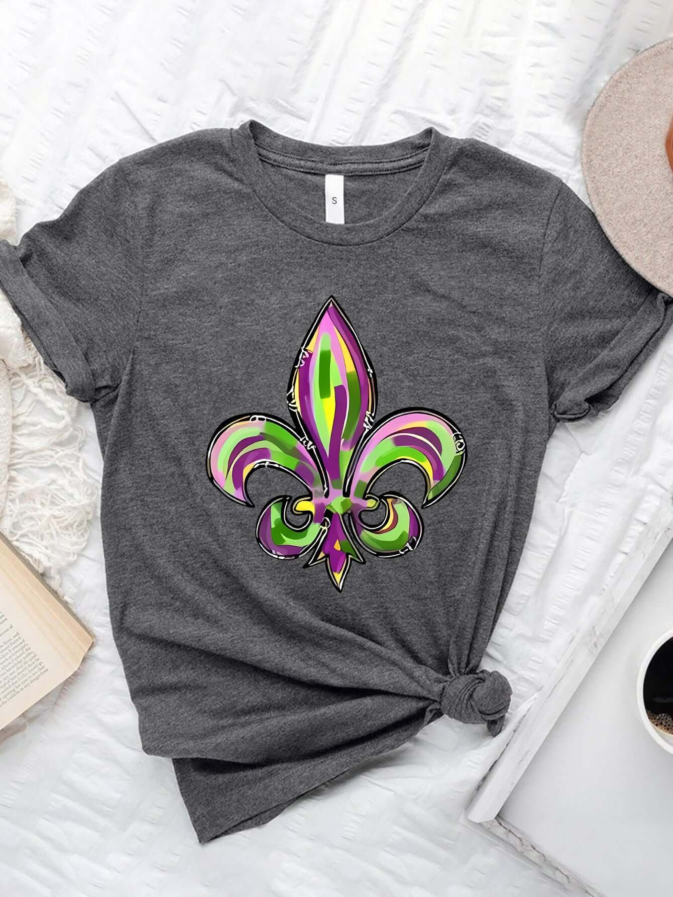 Bella Road Mardi Gras graphic T-shirt featuring vibrant purple and green fleur-de-lis design on a gray background.