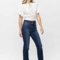 Woman wearing Judy Blue Frayed Hem Bootcut Jeans paired with a white blouse, showcasing trendy and stylish denim fashion.