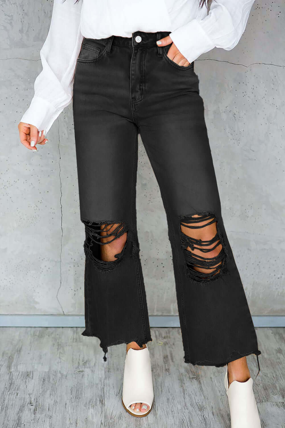 Distressed raw hem jeans with pockets in black, featuring trendy rips and white ankle boots, offering a stylish casual look.