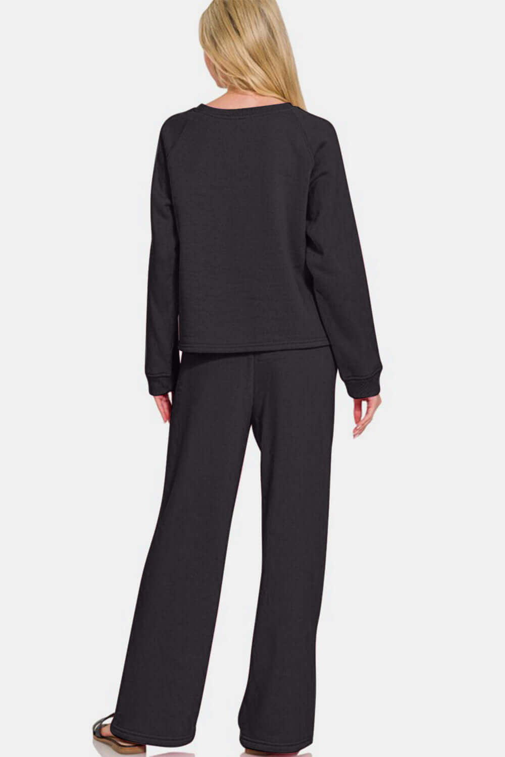 Woman wearing a black round neck raglan sleeve top and elastic waist pants set, showing the back view in a relaxed fit.